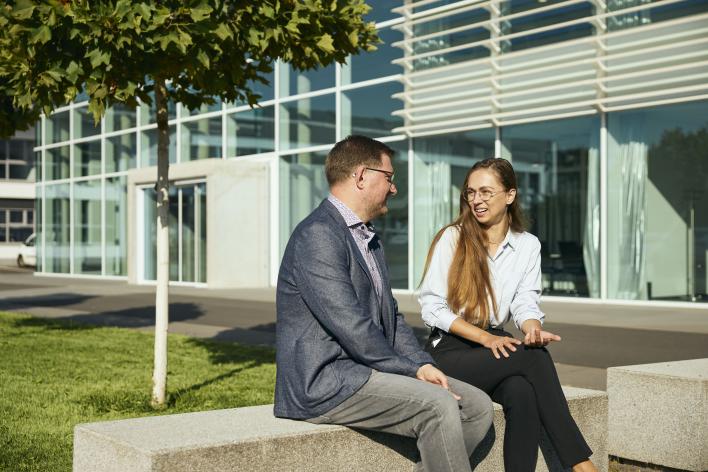 Zwei Personen unterhalten sich vor dem Woco Gebäude