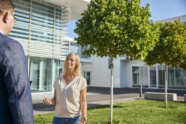 Zwei Mitarbeiter unterhalten sich vor dem Woco Gebäude 