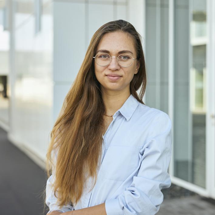 Mitarbeitende in blauem Shirt vor Woco Gebäude