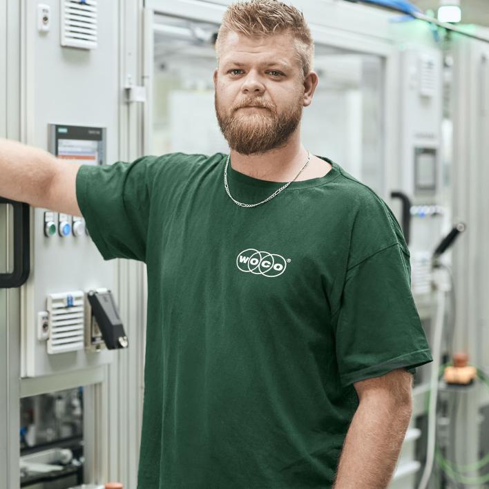 Mitarbeitender in grünem Woco Shirt in Fabrik